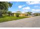 Charming home exterior featuring a well-manicured lawn, lush landscaping, and a paved driveway at 20 Idle Sands Dr, Venice, FL 34293