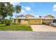 Charming home with a well-maintained lawn, yellow siding, and a neutral colored tile roof at 20 Idle Sands Dr, Venice, FL 34293