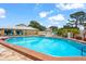Community pool with blue umbrellas, lounge chairs and tropical landscaping at 20 Idle Sands Dr, Venice, FL 34293