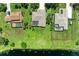 Aerial view of three homes with pools and generous backyards sloping to the lake, set in lush green landscape at 208 147Th Ne St, Bradenton, FL 34212