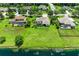 Aerial view of houses with spacious lots extending to a lake; neighborhood has lush landscaping and mature trees at 208 147Th Ne St, Bradenton, FL 34212