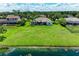 Aerial view of a home with a spacious backyard leading to a tranquil lake, surrounded by lush greenery at 208 147Th Ne St, Bradenton, FL 34212