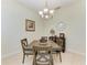 Cozy dining area with a chandelier, wooden table and chairs, complemented by a decorative mirror and artwork at 208 147Th Ne St, Bradenton, FL 34212