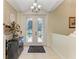 Bright foyer with decorative glass doors, tiled floor and traditional chandelier at 208 147Th Ne St, Bradenton, FL 34212