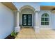Inviting front entrance features a decorative door, elegant columns, and neutral tile flooring at 208 147Th Ne St, Bradenton, FL 34212