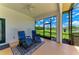 Enclosed lanai featuring two chairs and a picturesque view of the serene lake and lush greenery beyond at 208 147Th Ne St, Bradenton, FL 34212