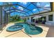 A screened-in pool and spa with an umbrella, perfect for relaxation and outdoor enjoyment at 208 147Th Ne St, Bradenton, FL 34212
