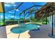 A covered patio overlooks a pool with attached spa, surrounded by a screened enclosure with lake view at 208 147Th Ne St, Bradenton, FL 34212