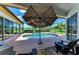 Outdoor pool and spa area with an umbrella for shade, surrounded by a screened enclosure at 208 147Th Ne St, Bradenton, FL 34212
