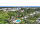 Aerial view of a backyard featuring a pool, green grass, and palm trees, offering a private outdoor oasis at 2220 Bahia Vista St # G4, Sarasota, FL 34239
