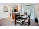 A dining room with dark wood table, seating for six and lots of natural light from the sliding glass doors to the patio at 2220 Bahia Vista St # G4, Sarasota, FL 34239
