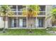 Exterior view of building, featuring a porch with a small table and palm trees at 2220 Bahia Vista St # G4, Sarasota, FL 34239