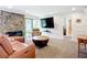 Spacious living room with a stone fireplace, mounted TV and large windows at 2220 Bahia Vista St # G4, Sarasota, FL 34239