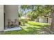 Outdoor patio with two Adirondack chairs and table overlooking the lush green lawn at 2220 Bahia Vista St # G4, Sarasota, FL 34239