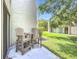 Outdoor patio with two Adirondack chairs and table overlooking the lush green lawn at 2220 Bahia Vista St # G4, Sarasota, FL 34239