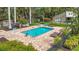 Beautiful pool area surrounded by lush tropical landscaping and a brick paved deck with several lounge chairs at 2220 Bahia Vista St # G4, Sarasota, FL 34239