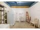 Unfinished basement featuring a white refrigerator, shelving and a ladder at 2513 Avenue B # B, Bradenton Beach, FL 34217