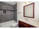 Bathroom featuring shower/tub with gray tile surround and wood vanity with modern mirror at 2513 Avenue B # B, Bradenton Beach, FL 34217