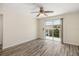 Bright, empty bedroom featuring wood-look floors, ceiling fan, and sliding glass doors to private deck at 2513 Avenue B # B, Bradenton Beach, FL 34217