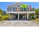 Charming beach house on stilts featuring a vibrant, decorated porch and convenient ground-level parking at 2513 Avenue B # B, Bradenton Beach, FL 34217