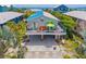Inviting coastal home featuring a colorful deck with outdoor seating, a ground-level parking area, and lush greenery at 2513 Avenue B # B, Bradenton Beach, FL 34217
