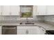 Updated kitchen features stainless appliances, granite counters, white cabinets, and tile backsplash at 2513 Avenue B # B, Bradenton Beach, FL 34217