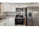 Modern kitchen with stainless steel appliances, white cabinets, granite countertops, and tile backsplash at 2513 Avenue B # B, Bradenton Beach, FL 34217