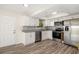 Modern kitchen with stainless steel appliances, white cabinets, granite countertops, and wood-look floors at 2513 Avenue B # B, Bradenton Beach, FL 34217