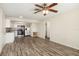 Open-concept living room boasts updated kitchen, wood floors, and contemporary ceiling fan fixture at 2513 Avenue B # B, Bradenton Beach, FL 34217