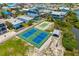 Aerial showcases tennis and basketball courts surrounded by lush landscaping and nearby houses at 2513 Avenue B # B, Bradenton Beach, FL 34217