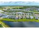 An aerial view shows a house nestled among many other single Gathering homes around a pond at 2565 Star Apple Way, Sarasota, FL 34240