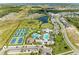 An aerial view showcases the community, highlighting the tennis courts, pool area, pond, and green spaces at 2565 Star Apple Way, Sarasota, FL 34240