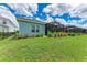 Landscaped backyard with a screened-in patio area and lush green lawn at 2565 Star Apple Way, Sarasota, FL 34240