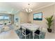 Bright dining room featuring a modern chandelier, large painting, and view to the living area and backyard at 2565 Star Apple Way, Sarasota, FL 34240