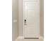 A modern, paneled front door with keyless entry, framed by neutral walls and tiled flooring at 2565 Star Apple Way, Sarasota, FL 34240