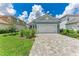 A single-story home featuring a well-manicured lawn, gray paver driveway, and a classic white two-car garage door at 2565 Star Apple Way, Sarasota, FL 34240