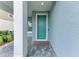 Inviting entryway with a teal front door, paver flooring, and a view of the landscaped front yard at 2565 Star Apple Way, Sarasota, FL 34240