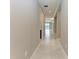 A bright hallway features tiled floors, neutral walls, crown molding, and a view to the living space and outdoor scenery at 2565 Star Apple Way, Sarasota, FL 34240