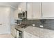 Kitchen showcases stainless steel oven, granite countertops, and dark subway tile backsplash at 2565 Star Apple Way, Sarasota, FL 34240
