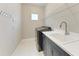 Well-organized laundry room with a modern washer/dryer, sink, and ample counter space at 2565 Star Apple Way, Sarasota, FL 34240