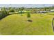 Aerial view of a large, open, green field with a small tree and a partially visible black fence at 2565 Star Apple Way, Sarasota, FL 34240