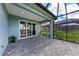 Covered outdoor brick patio with a screened enclosure that connects to the house through sliding glass doors at 2565 Star Apple Way, Sarasota, FL 34240