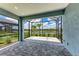 Screened in patio with brick pavers overlooking lush landscaping and serene water views at 2565 Star Apple Way, Sarasota, FL 34240