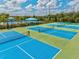 Aerial view of tennis courts with lounge area and palm trees in a community at 2565 Star Apple Way, Sarasota, FL 34240