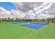 Multiple blue and green community tennis courts with shelters and landscaping for active recreation at 2565 Star Apple Way, Sarasota, FL 34240