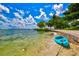 Beautiful waterfront view with a blue kayak resting on the sandy shore at 2565 Star Apple Way, Sarasota, FL 34240