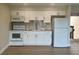 Bright kitchen featuring white cabinetry, stone countertops, and stainless steel appliances at 2636 Hidden Lake N Dr # G, Sarasota, FL 34237