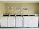 On-site laundry room with rows of commercial washing machines and clear posted instructions at 2636 Hidden Lake N Dr # G, Sarasota, FL 34237