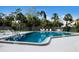 Large community pool with lounge chairs and tables surrounded by a fence and mature trees at 2904 64Th W St # 2904, Bradenton, FL 34209