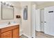 Bathroom featuring a vanity with a sink, a large mirror, and multiple doors providing access at 3045 Logue Rd, Myakka City, FL 34251